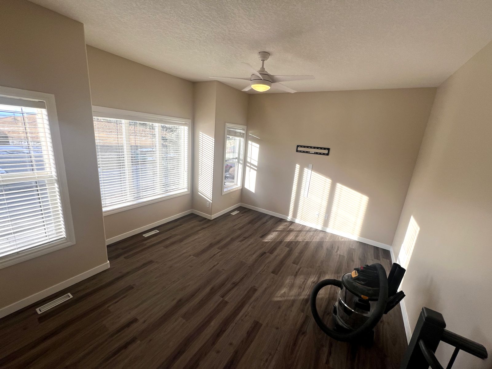 Main floor room with new wide plank flooring and fresh paint