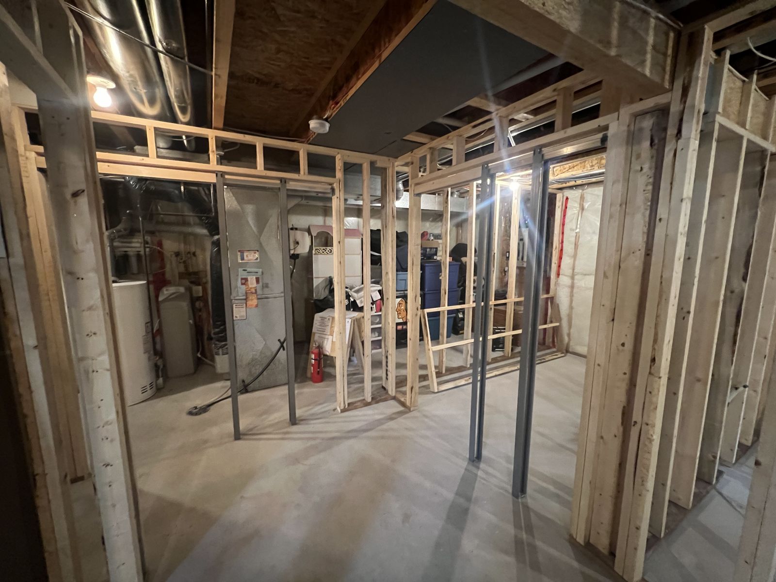 Basement under construction showing new wall framing and rough-in plumbing